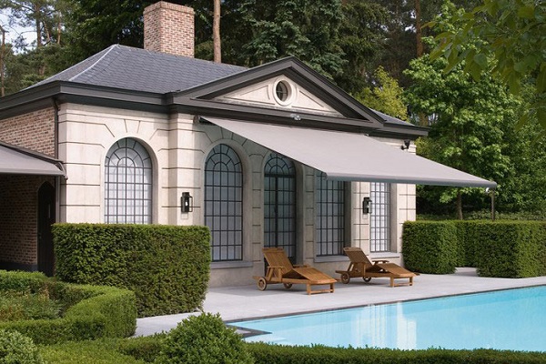 Die Terrassenmarkise Opal Design 2 in grau an nostalgischem Ferienhaus mit Pool und Garten. Klicken um zur Opal Design 2 Info zu gelangen.
